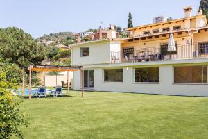 une maison avec une grande cour avec un gazebo dans l'établissement villa Jarana, à Lloret de Mar