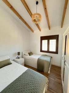 ein Schlafzimmer mit zwei Betten und einem Fenster in der Unterkunft Casa Rural Villa Soleá in Algarrobo