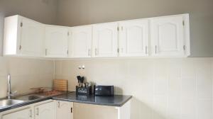 a kitchen with white cabinets and a counter top at Comfy stay in East London +25 photos