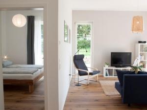 une chambre avec un lit, une chaise et une télévision dans l'établissement Ferienscheune, à Daisendorf