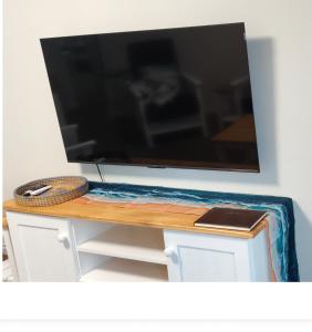Un televisor de pantalla plana sobre una mesa. en Dunes Alcove, en Mossel Bay