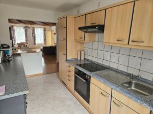 a kitchen with wooden cabinets and a stove top oven at Gemütliche Ferienwohnung nähe Wutachschlucht in Hüfingen