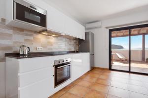 eine Küche mit weißen Geräten und Blick auf das Meer in der Unterkunft Casa Las Vistas in Gran Tarajal + 19 Fotos