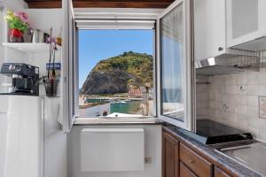 a kitchen with a window with a view of the ocean at Casatullio - Sant'Angelo d'Ischia in Ischia
