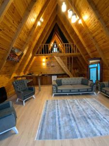 Una sala de estar con sofás y sillas en una cabaña. en Moon Bungalov, en Sapanca