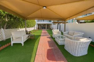an outdoor patio with chairs and an umbrella at فيلا برادايس in Jeddah