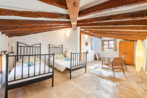 een slaapkamer met 2 bedden in een kamer met houten plafonds bij Casa Romana in Pollença +21 foto's