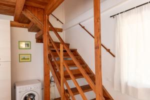 a wooden staircase in a laundry room with a washing machine at Il Nazareno - Civetta in Cecina
