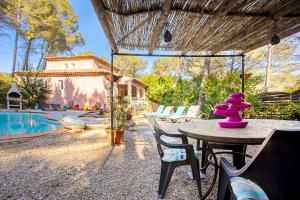 Un patio con mesa y sillas y una piscina. en Villa Les Clémentines, en Trans-en-Provence