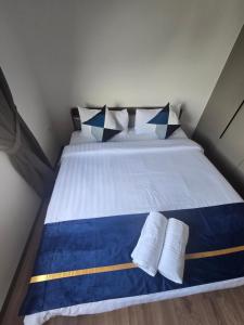 a bed with two pillows and two towels on it at Jenz Homestay - 2 in Bintulu