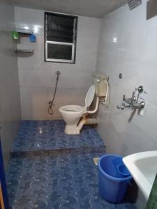 une salle de bain avec toilettes et sol bleu dans l'établissement Tuka Maka Homestay, à Malvan