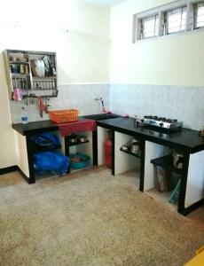 une cuisine avec un bureau noir et un comptoir dans l'établissement Tuka Maka Homestay, à Malvan