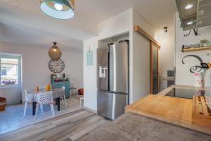 a kitchen with a stainless steel refrigerator and a table at Gite Leoannatim in Ruoms