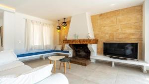 a living room with a fireplace and a tv at Apartamento Guillem in Cala de Sant Vicent