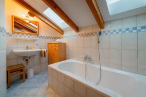 a bathroom with a tub and a sink at Ferienwohnung Westernberg in Ruhpolding +8 photos