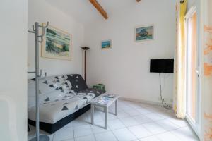 a living room with a bed and a table at Villa Avec Piscine partagée in Cap d'Agde