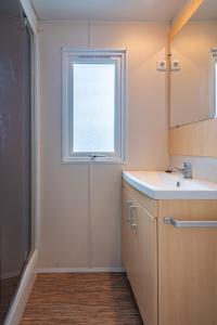a bathroom with a sink and a window at Mobil-home Elegance - 3 chambres in Seillac