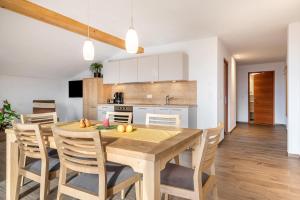 a kitchen and dining room with a wooden table and chairs at Reiterhof Apt Flora in San Genesio Atesino +31 photos