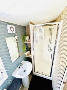 ein Badezimmer mit Dusche und Waschbecken in der Unterkunft Holiday Home with Hot Tub Cornish Country SeaSide in Newquay Bay Resort