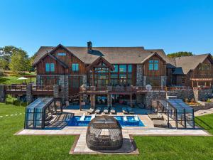 a large house with a swimming pool in front of it at Pinnacle Pointe by Relaxtay 600 Acre Private Luxury Estate with Spa, Pool, Theater and Lake in High View