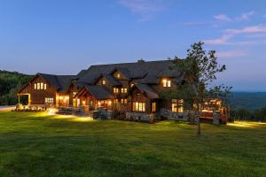 a large house on a grassy field at night at Pinnacle Pointe by Relaxtay 600 Acre Private Luxury Estate with Spa, Pool, Theater and Lake in High View