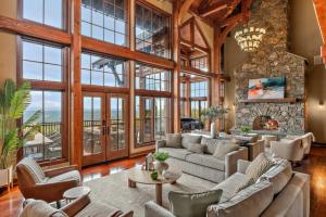a living room filled with furniture and a stone fireplace at Pinnacle Pointe by Relaxtay 600 Acre Private Luxury Estate with Spa, Pool, Theater and Lake in High View