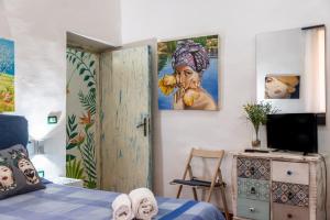 a bedroom with a bed and a painting of a woman at Cumellart 1 in Agrigento