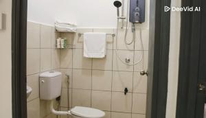 une salle de bain avec des toilettes blanches et une douche dans l'établissement Feel Borneo Cozy Homestay in Penampang, à Penampang