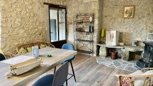 a room with a table and chairs and a stone wall at Mas de Charme - Les Angelettes in Saint-Ferréol-Trente-Pas
