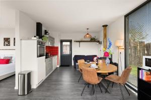 a kitchen and living room with a table and chairs at NEW! Vakantiehuis Grijpskerke met airco en houtkachel - 2 personen in Grijpskerke