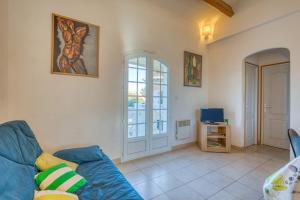 a living room with a blue couch and a window at La Madrague St Vincent Apt A in Le Grau-dʼAgde