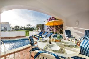 a dining room with a table and chairs and a swimming pool at Mng Elliott42 in Vale do Lobo