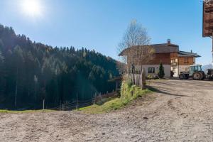 un chemin de terre à côté d'une maison avec un tracteur dans l'établissement Innerjerberhof Neiderseit, à Lauregno