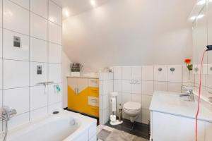 une salle de bain avec une baignoire, des toilettes et un lavabo dans l'établissement Ferienwohnung am Rosenberg, à Stockach 21 autres photos