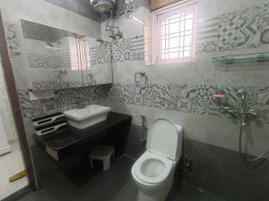 a bathroom with a white toilet and a sink at 2BHK Central Gurgaon in Gurgaon +14 photos