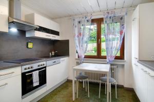 a kitchen with white cabinets and a table and a window at Ferienwohnung Marie in Niedereschach