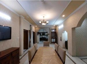 a living room with chairs and a flat screen tv at 2BHK Central Gurgaon in Gurgaon