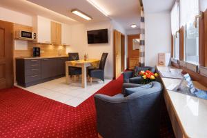 une cuisine et un salon avec une table et des chaises dans l'établissement Gästehaus Wolfgang Königsee -8-, à Ruhpolding