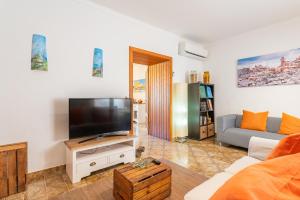 sala de estar con TV y sofá en Pegaso - Ca’n Vicenç, en Campanet