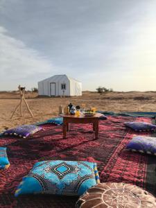 a table in the middle of a desert with a tent at Silent Camp in Mhamid
