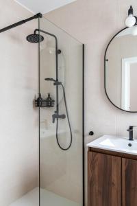 a bathroom with a shower with a sink and a mirror at Iberos Home in Seville +15 photos