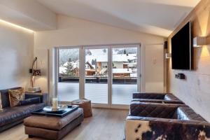 a living room with leather furniture and a large window at Haus Excelsior Top 38 in Seefeld in Tirol
