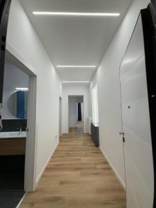 un pasillo con paredes blancas y suelo de madera en Tara Homes, en Trieste 13 fotos más