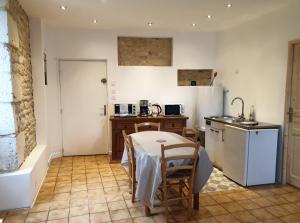 a kitchen with a table and a sink and a table and chairs at Studio 5 - 3 min du Futuroscope in Chasseneuil-du-Poitou
