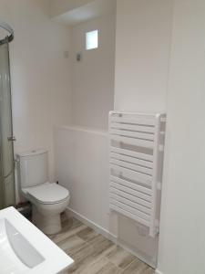 a white bathroom with a toilet and a sink at Studio 5 - 3 min du Futuroscope in Chasseneuil-du-Poitou +2 photos