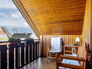 een balkon met 2 stoelen en een houten plafond bij Ferienwohnung bei Fredy in Langenargen