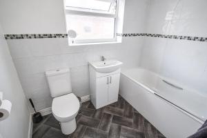 ein Badezimmer mit Toilette, Waschbecken und Badewanne in der Unterkunft Beach Meets City - Two Bed Stay Near to Liverpool in Wallasey