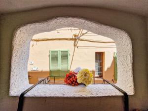 a window with a bowl of flowers on a table at Il Borgo 5 in Capoliveri