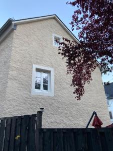 a house with two windows and a wooden fence at Eifeloase in Birresborn