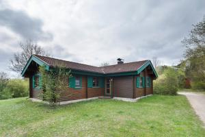 a small house with green windows on a grass field at Hüssli Numero 1 in Hayingen